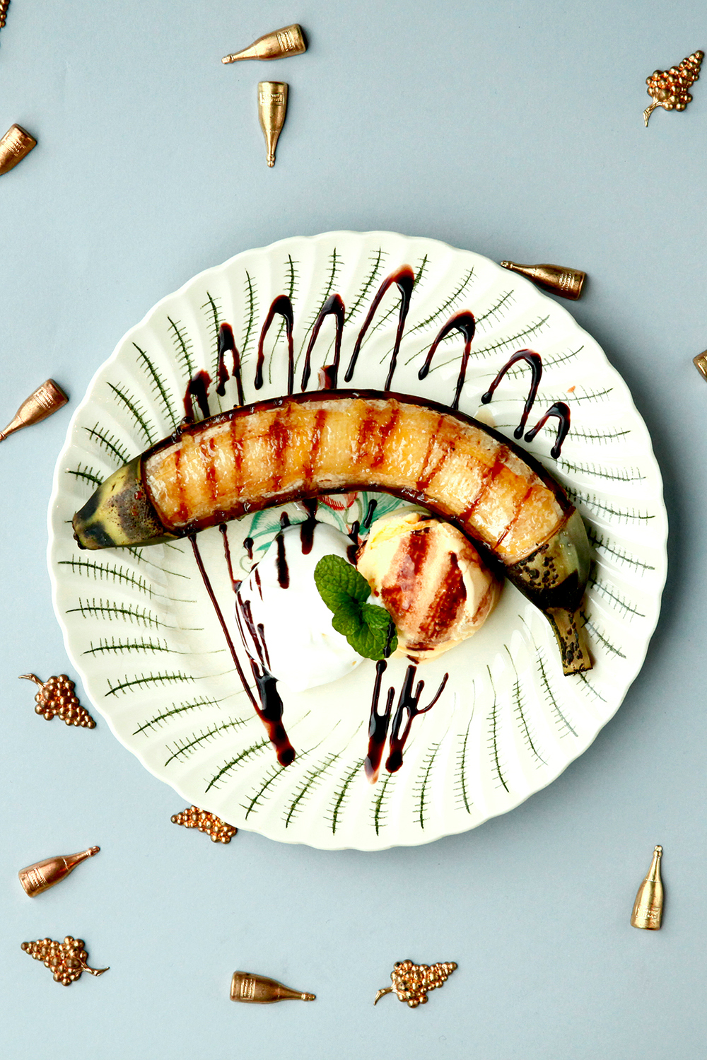 縦半分に切って焼き目をつけたバナナに生クリームとカラメルソースをかけ、アンティークの絵皿に盛り付けた名物デザート「焼きバナナ」(アンティーク&オールディーズ公式サイトより)