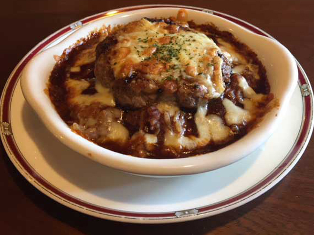 白い器の中で、とろけたチーズとデミグラスソースに包まれたハンバーグドリア(カフェリーフ公式サイトより)