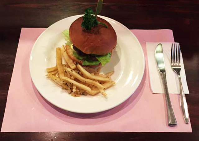 白いお皿にのったバンズのハンバーガーとポテト、ピンクのランチョンマットとナイフ・フォーク(カフェリーフ公式サイトより)