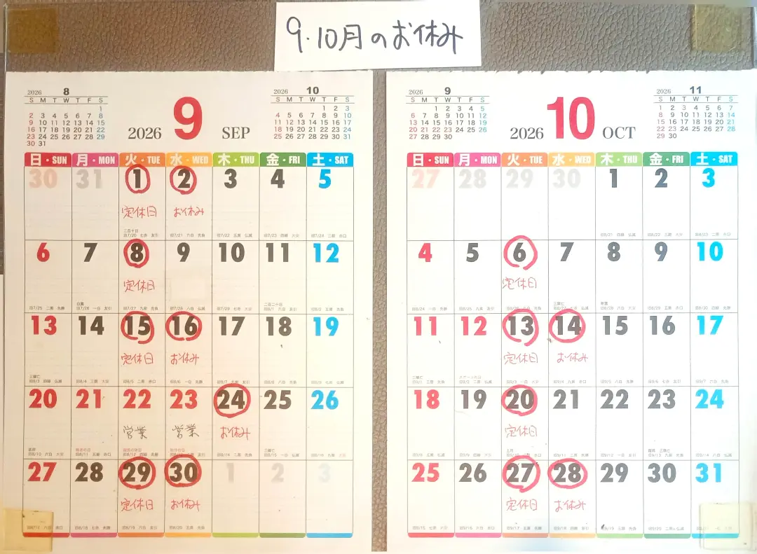 「9・10月のお休み」と手書きされた壁掛けカレンダー。定休日とお休みの日が赤ペンで丸く囲まれているガーデンカフェカモミールの営業日案内(カモミール公式Instagramより)