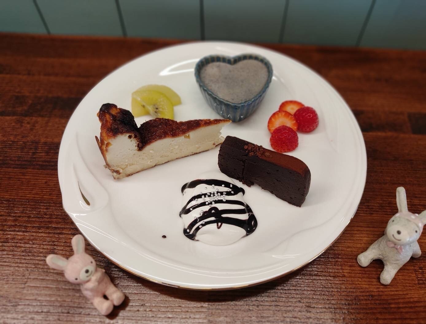 花cafeの手作りデザート3種盛り。バスクチーズケーキ、ガトーショコラ、黒ごまプリンにキウイとイチゴが添えられている(花cafe公式サイトより)