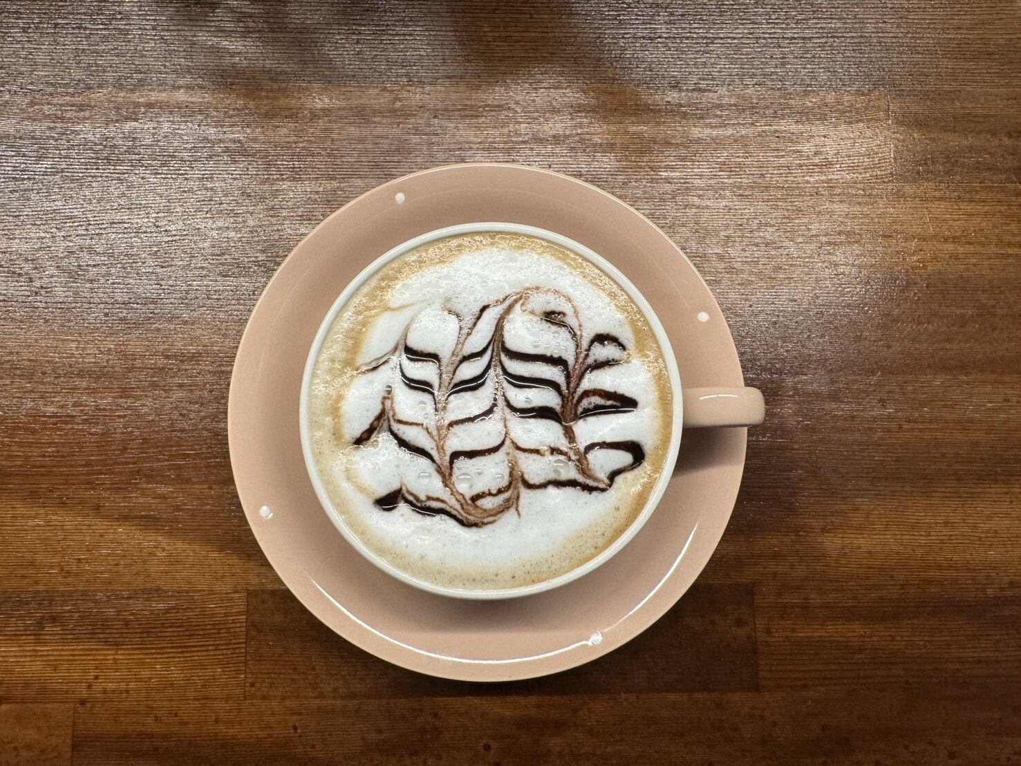葉の模様が描かれた花cafeのカフェラテ(花cafe公式サイトより)