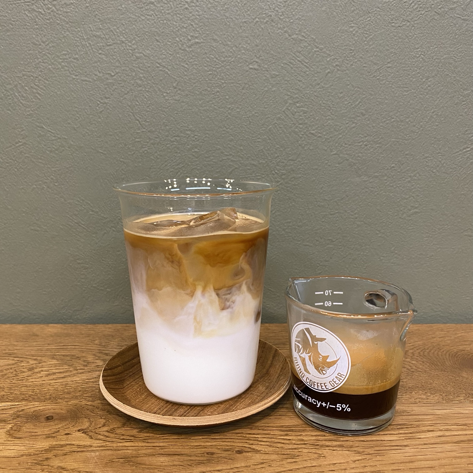 コーヒーとミルクがマーブル模様になったアイスカフェラテと、エスプレッソの入ったショットグラス（The Little Coffee Stand公式サイトのメニューページより）