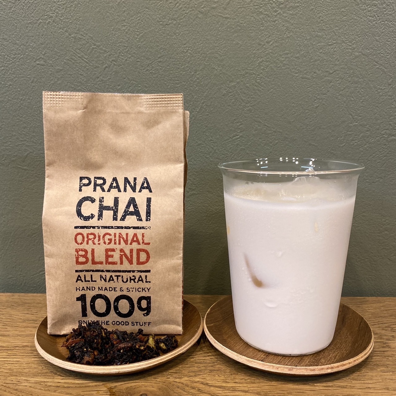 PRANA CHAI ORIGINAL BLENDのクラフト袋と茶葉、グラスに入ったアイスチャイ(The Little Coffee Stand公式サイトのメニューページより)