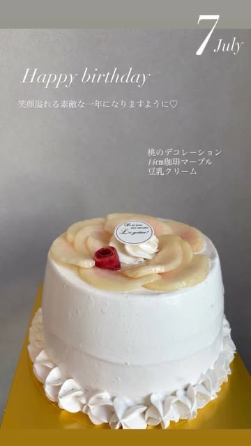 「Happy birthday 笑顔溢れる素敵な一年になりますように♡ 桃のデコレーション 14cm珈琲マーブル 豆乳クリーム」の文字と、桃をのせた白いデコレーションケーキ（Sana all公式Instagramより）
