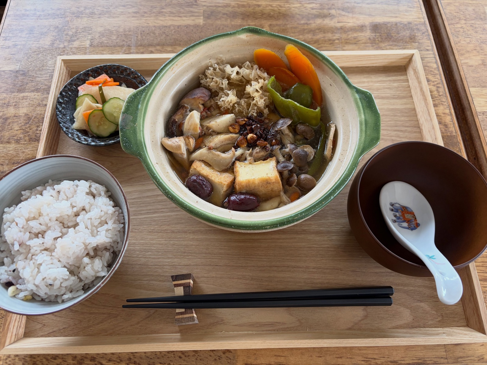 水穀茶房の季節の滋養鍋。きのこや豆腐、白キクラゲ、にんじんが入った土鍋に雑穀ごはんと小鉢が添えられている（公式Instagramより）