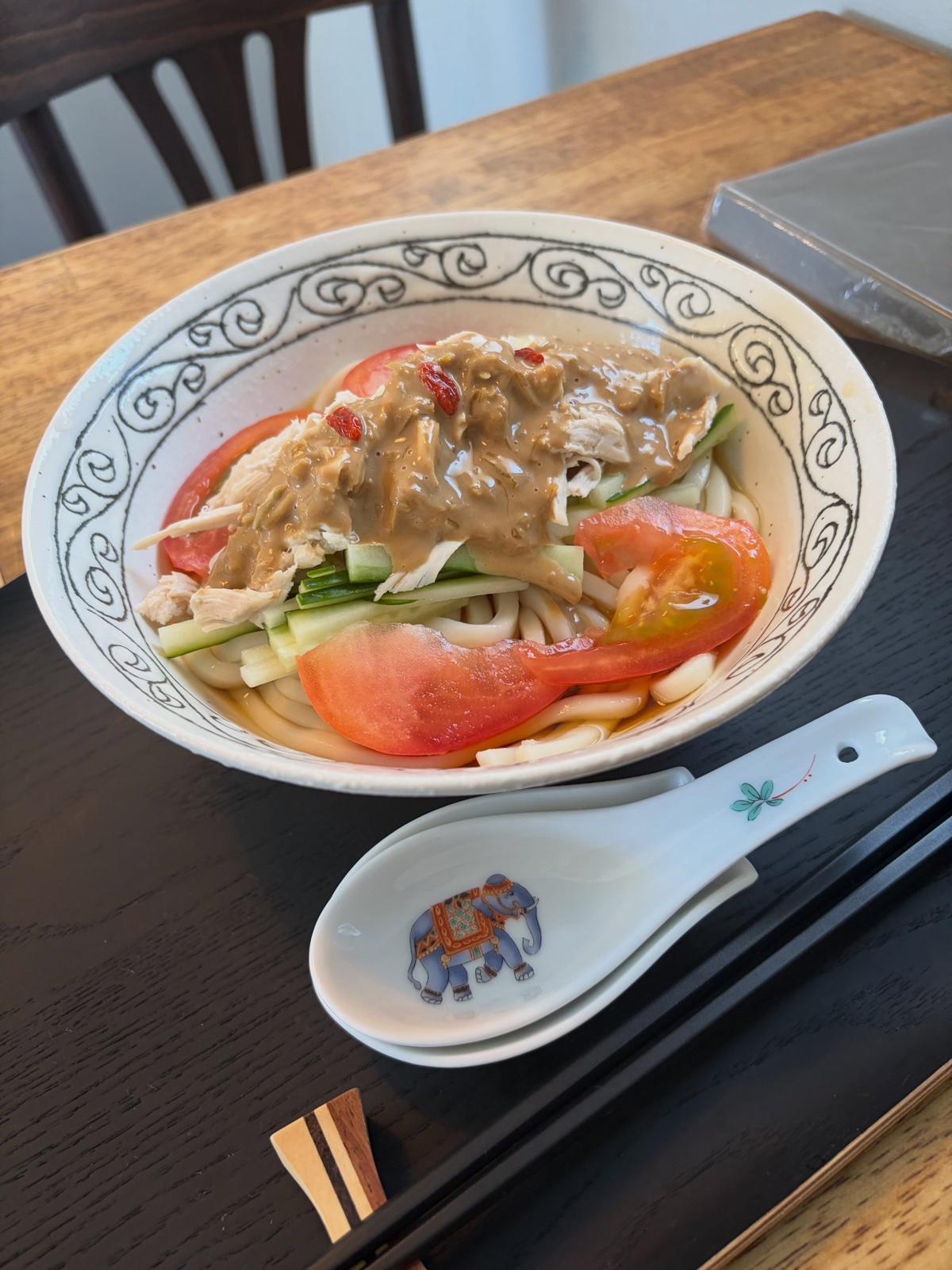 水穀茶房の冷やし棒棒鶏うどん。うどんの上に蒸し鶏、トマト、きゅうり、ごまだれがかかっている（公式Instagramより）