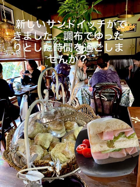 ガラスドームのバスケットに山盛りになったサンドイッチと、手前にハムとレタスをはさんだサンドイッチのアップ。奥には満席の店内が写る(The English Cafe公式Instagramより)