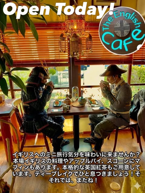 The English Cafeの店内。木のブラインドとシャンデリアの下、甲冑姿の人形2体が向かい合ってティーカップを傾けている「Open Today!」の告知画像(The English Cafe公式Instagramより)