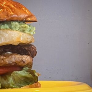 角島OZ BURGERの関門ポークパティバーガーの断面、レタスやアボカド、パティが層になった写真(公式Instagramより)