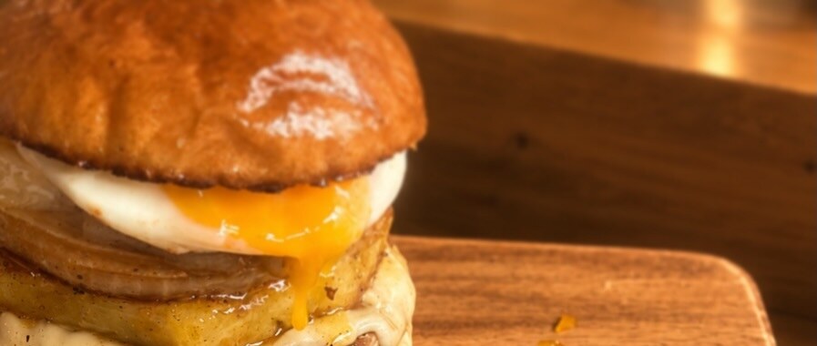 角島OZ BURGERの目玉焼きがのったバーガー、黄身がとろけている様子(公式Instagramより)