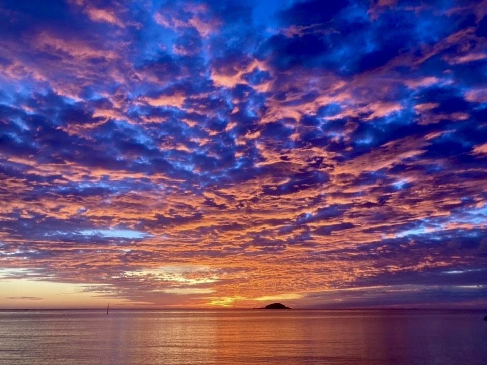 空一面に広がるオレンジと青の雲と、夕焼けに染まる海、水平線に浮かぶ小島（ZERO CAFE公式サイトより）