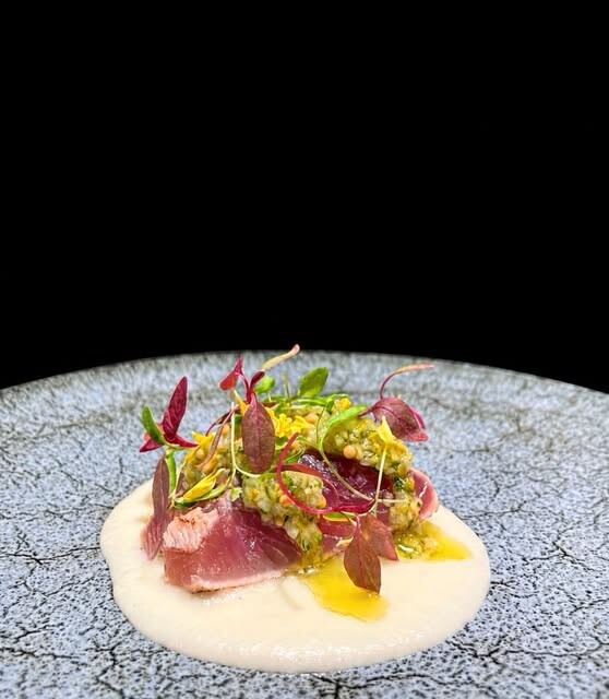 ラ・カシェットの前菜。赤身魚を低温調理しハーブと花を添えた一皿(公式Instagramより)