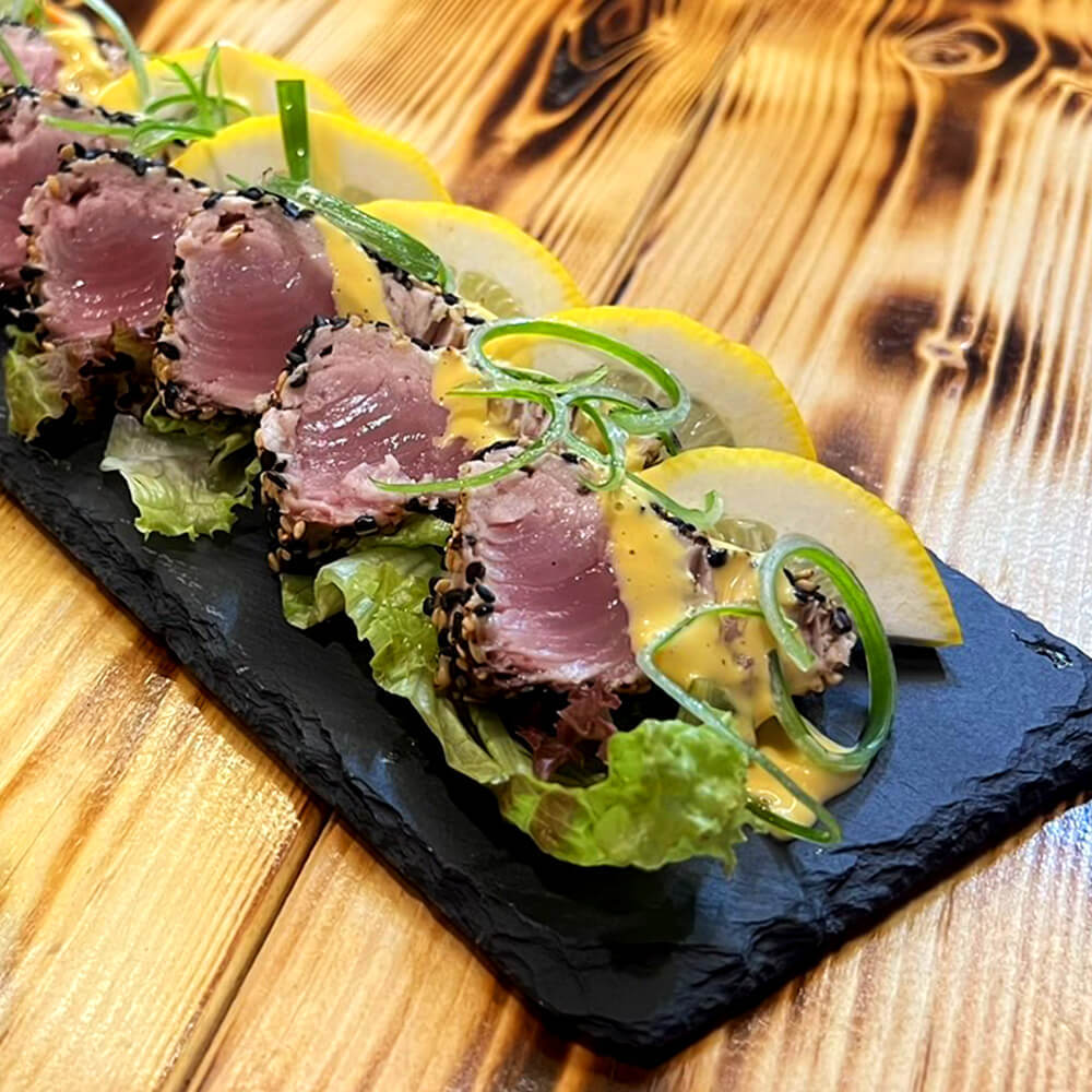 MR.CEYLONの黒ごまマグロタタキ。レモンとレタスを添えたスレート皿に盛り付け(公式サイトより)