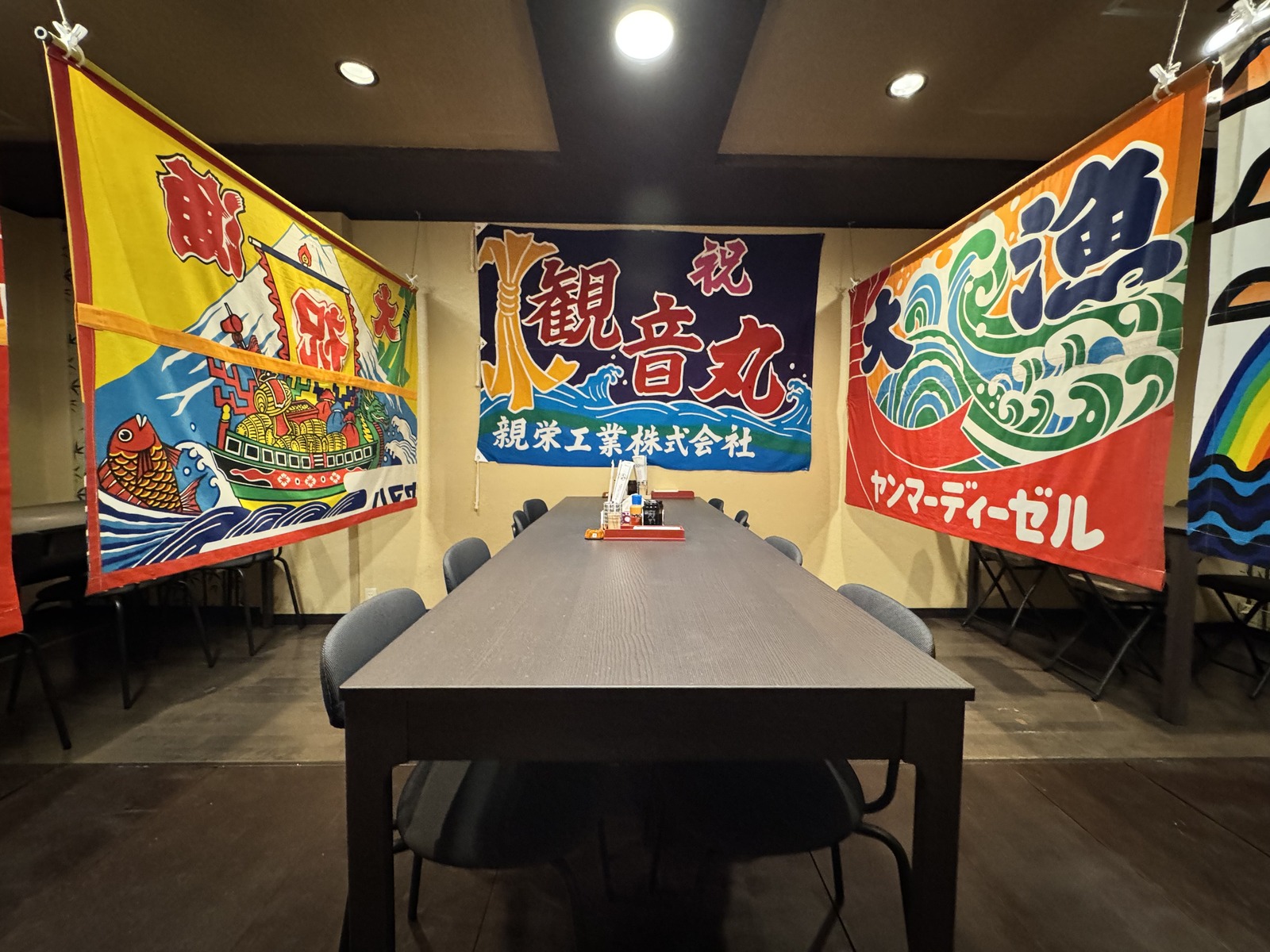 観音丸の大テーブル席と大漁旗(公式サイトより)