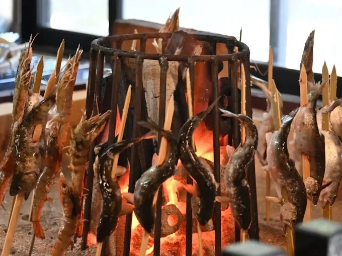 炭火で焼かれる串打ちの魚介（流王公式サイトより）